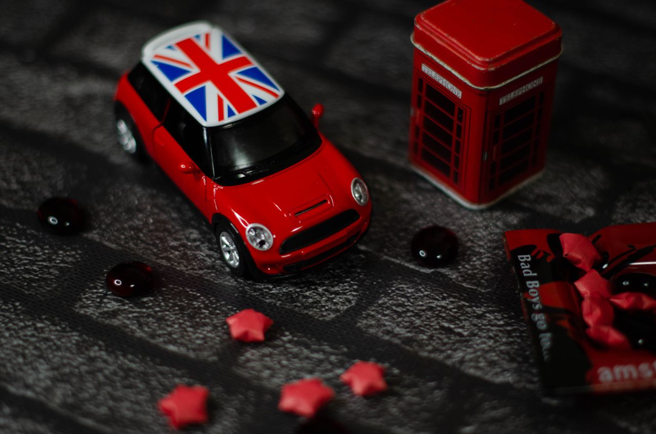 Close-up of a red toy Mini Cooper with a Union Jack roof and a mini phone box.