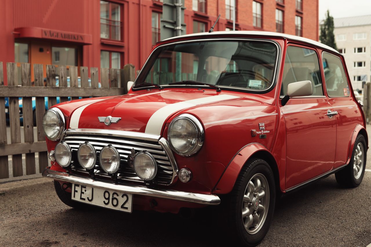Classic red Mini Cooper parked on a Jönköping street, exuding vintage charm.