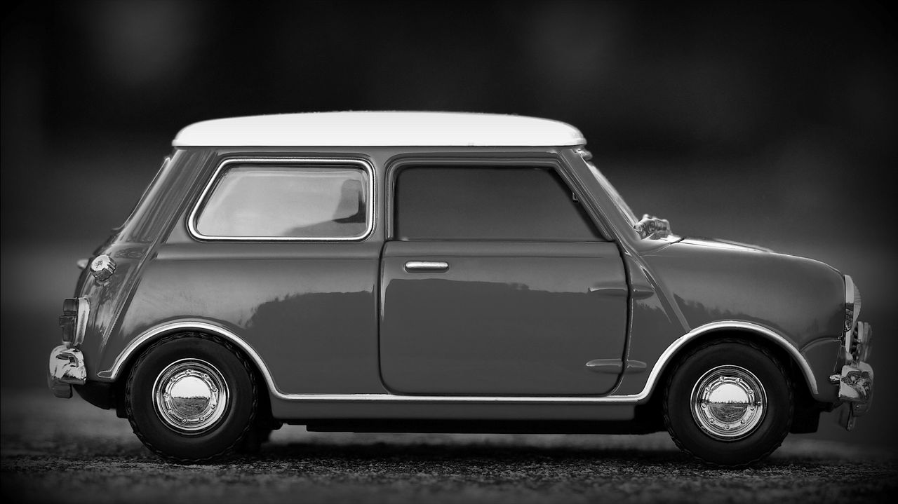 Close-up of a classic Mini toy car in monochrome, highlighting elegant design.